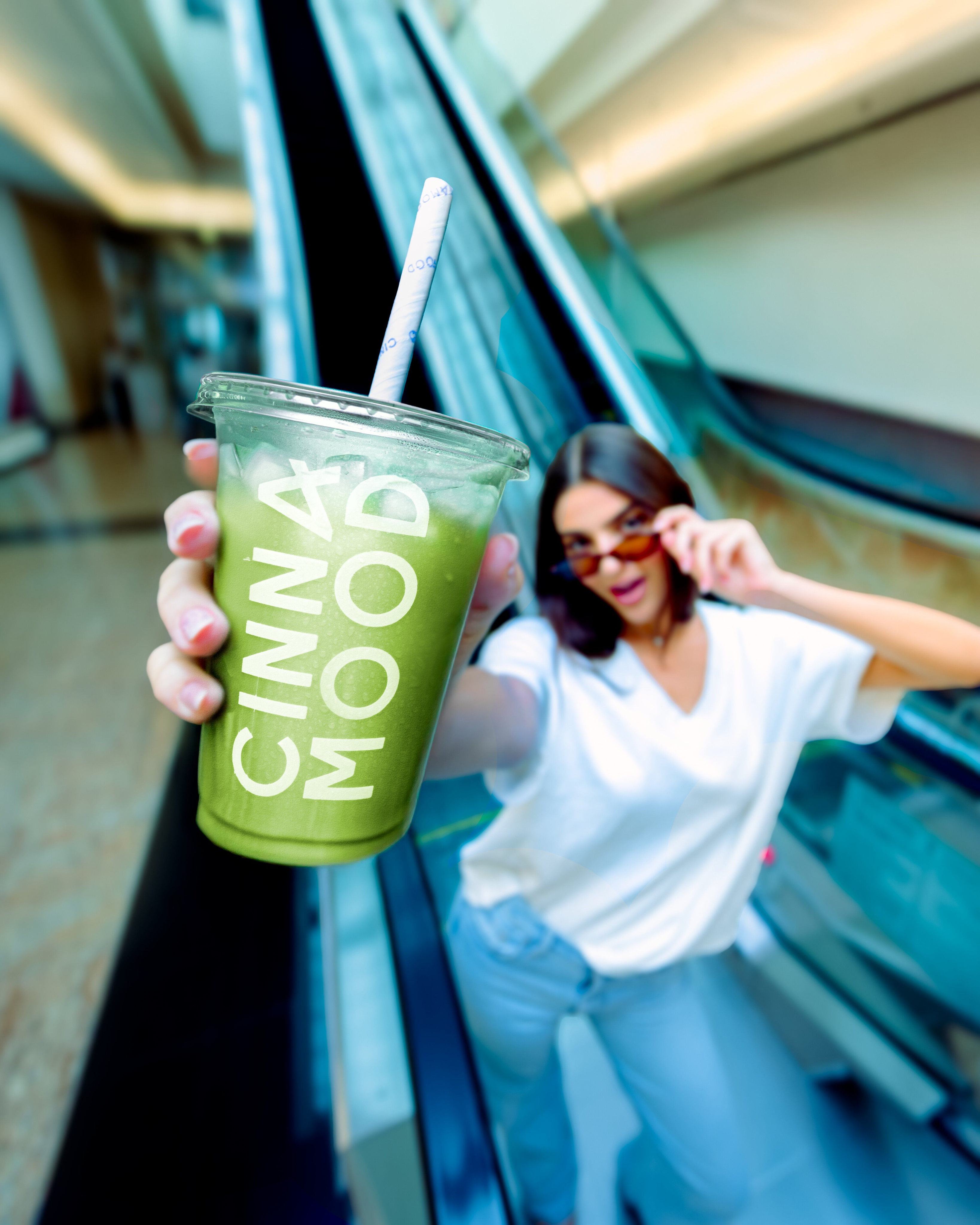 Cinnamood drink held on an escalator